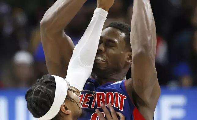 New York Knicks guard Miles McBride, left, defends against a shotort by Detroit Pistons center Jalen Duren, right, during the first half of an NBA basketball game Thursday, April 10, 2025, in Detroit. (AP Photo/Duane Burleson)