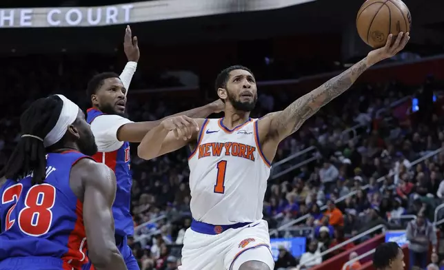 New York Knicks forward Precious Achiuwa (5) goes to the basket past Detroit Pistons center Isaiah Stewart (28) and guard Malik Beasley, center, during the first half of an NBA basketball game Thursday, April 10, 2025, in Detroit. (AP Photo/Duane Burleson)