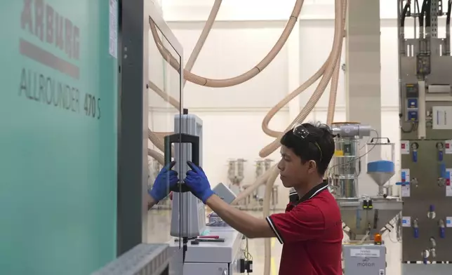 A worker operates a moulding machine at Lego factory in Binh Duong, Vietnam Wednesday, April 2, 2025. (AP Photo/Hau Dinh)