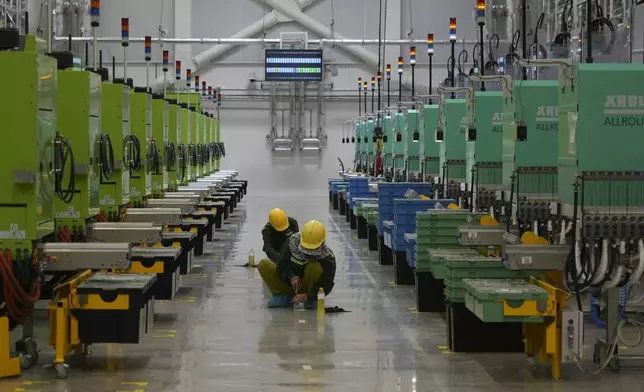 Workers scrub the floor at Lego factory in Binh Duong, Vietnam Wednesday, April 2, 2025. (AP Photo/Hau Dinh)