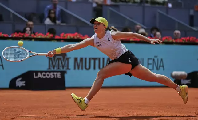 Iga Swiatek of Poland returns the ball against Russia's Diana Shnaider during the Madrid Open tennis tournament in Madrid, Spain, Tuesday, April 29, 2025. (AP Photo/Manu Fernandez)