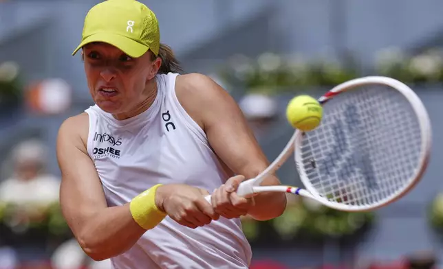 Iga Swiatek of Poland returns the ball against Russia's Diana Shnaider during the Madrid Open tennis tournament in Madrid, Spain, Tuesday, April 29, 2025. (AP Photo/Manu Fernandez)