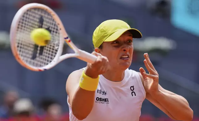 Iga Swiatek of Poland returns the ball against Russia's Diana Shnaider during the Madrid Open tennis tournament in Madrid, Spain, Tuesday, April 29, 2025. (AP Photo/Manu Fernandez)