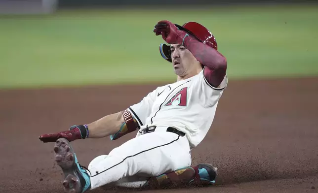 Arizona Diamondbacks' Corbin Carroll slides safely into third base with a triple against the Atlanta Braves during the first inning of a baseball game Sunday, April 27, 2025, in Phoenix. (AP Photo/Ross D. Franklin)