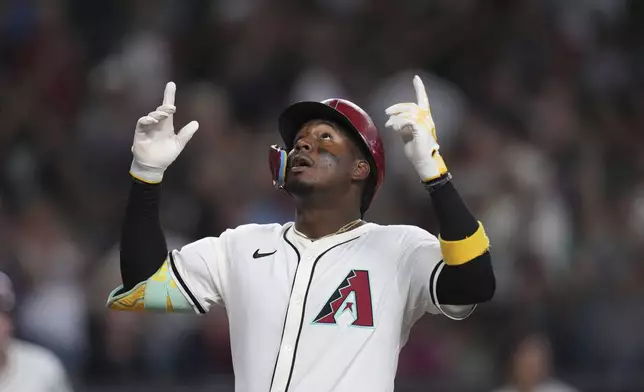 Arizona Diamondbacks' Geraldo Perdomo looks up as he arrives at home plate after hitting a home run against the Atlanta Braves during the fifth inning of a baseball game Sunday, April 27, 2025, in Phoenix. (AP Photo/Ross D. Franklin)