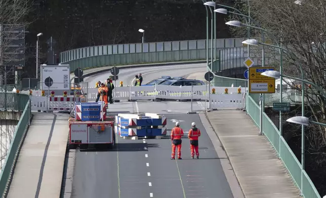 A heavy-duty module loaded with weights drives over the closed Elbe bridge as part of a three-day load test intended to show that the Elbe crossing can be reopened to traffic, in Bad Schandau, Germany, Tuesday April 1, 2025. (Sebastian Kahnert/dpa via AP)