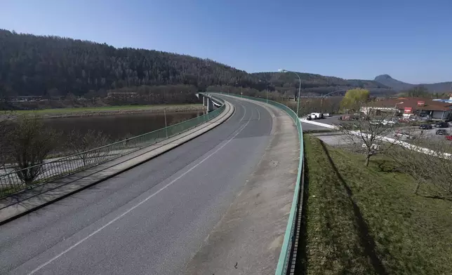 Cars parked next to the closed Elbe bridge a few days before its inauguration, in Bad Schandau, Germany, Friday March 28, 2025. (Sebastian Kahnert/dpa via AP)