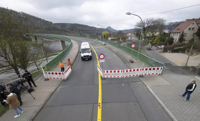 A traffic engineering vehicle crosses the Elbe bridge in Bad Schandau to mark the opening to traffic, in Dresden, Germany, Thursday April 10, 2025. (Sebastian Kahnert/dpa via AP)