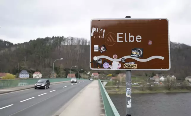 Cars cross the Elbe bridge in Bad Schandau to mark the opening to traffic, in Dresden, Germany, Thursday April 10, 2025. (Sebastian Kahnert/dpa via AP)