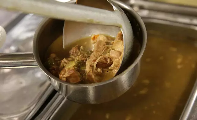 FILE - Sous chef Darren Chabert serves up chicken and andouille gumbo at Emeril's Delmonico in New Orleans, Monday, Feb. 17, 2014. (AP Photo/Gerald Herbert, File)