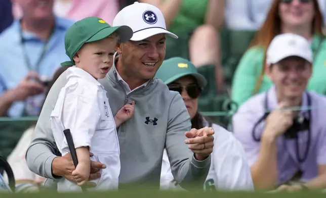 Jordan Spieth interacts with son Sammy during the par-3 contest at the Masters golf tournament, Wednesday, April 9, 2025, in Augusta, Ga. (AP Photo/George Walker IV)