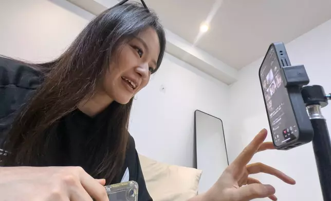 Tian Xin, a cyber matchmaker, hosts a livestream using the Chinese social media app Xiaohongshu (RedNote) from Hangzhou, China, early Friday, April 25, 2025. (AP Photo/Ng Han Guan)