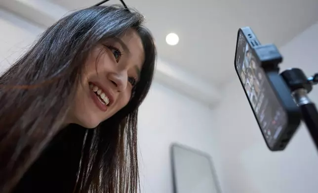 Tian Xin, a cyber matchmaker, hosts a livestream using the Chinese social media app Xiaohongshu (RedNote) from Hangzhou, China, early Friday, April 25, 2025. (AP Photo/Ng Han Guan)