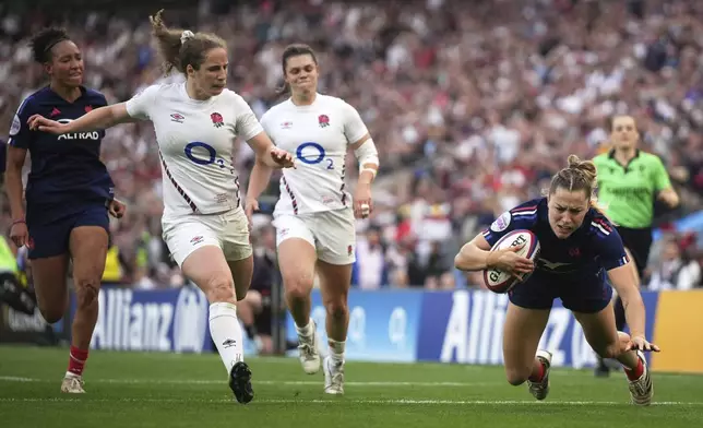 Joanna Grisez of France, right, dives over the line to score a try during the Women's Six Nations rugby union match at Twickenham stadium in London, Saturday, April 26, 2025. (AP Photo/Alastair Grant)