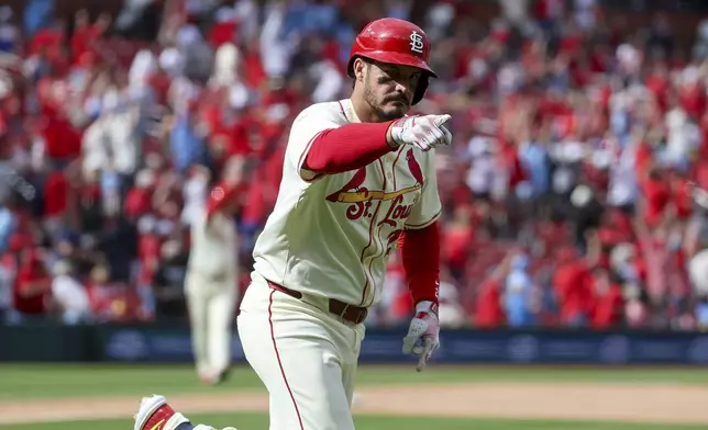 St. Louis Cardinals' Nolan Arenado points to the dugout as he runs the bases after hitting a walk-off solo home run during the ninth inning of a baseball game against the Milwaukee Brewers Saturday, April 26, 2025, in St. Louis. (AP Photo/Scott Kane)
