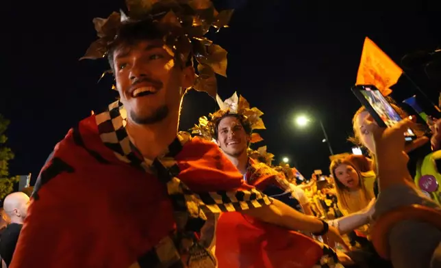 People welcome 80 Serbian university students who cycled more than 1,300 kilometers (780 miles) during last week, from Novi Sad to Strasbourg, France, to draw EU attention to their months-long protests against corruption, in Novi Sad, Serbia, Tuesday, April 22, 2025. (AP Photo/Darko Vojinovic)