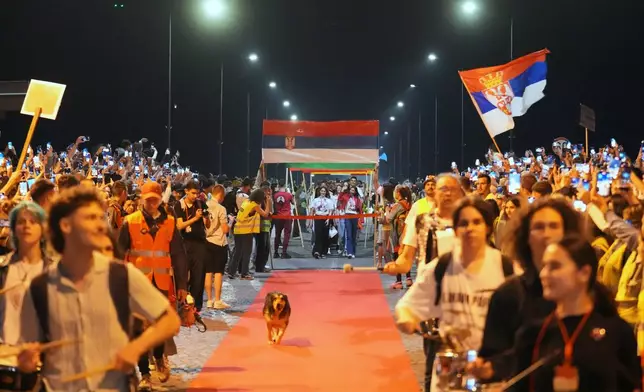 People welcome 80 Serbian university students who cycled more than 1,300 kilometers (780 miles) during last week, from Novi Sad to Strasbourg, France, to draw EU attention to their months-long protests against corruption, in Novi Sad, Serbia, Tuesday, April 22, 2025. (AP Photo/Darko Vojinovic)