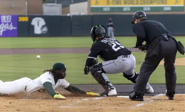 Chicago White Sox catcher Matt Thaiss (29) attempts to tag out Athletics' Lawrence Butler, left, during the first inning of a baseball game Sunday, April 27, 2025, in West Sacramento, Calif. (AP Photo/Sara Nevis)