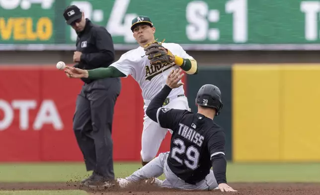 Athletics second baseman Luis Urías, center, turns a double play after getting Chicago White Sox's Matt Thaiss (29) out at second during the eighth inning of a baseball game Sunday, April 27, 2025, in West Sacramento, Calif. (AP Photo/Sara Nevis)