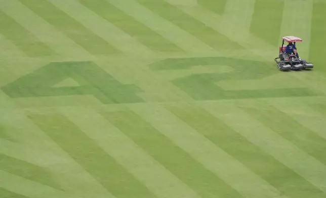 The number 42 is placed on the outfield grass at Dodger Stadium to commemorate Jackie Robinson Day before a baseball game between the Los Angeles Dodgers and Colorado Rockies Tuesday, April 15, 2025, in Los Angeles. (AP Photo/Damian Dovarganes)