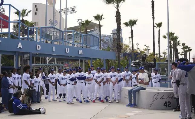 Former NBA basketball player Kareem Abdul-Jabbar speaks to members of the Los Angeles Dodgers and Colorado Rockies to commemorate Jackie Robinson Day before a baseball game at Dodger Stadium Tuesday, April 15, 2025, in Los Angeles. (AP Photo/Damian Dovarganes)