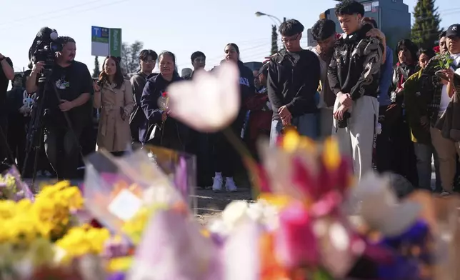 People visit a memorial after a vehicle drove into a crowd during a Filipino heritage festival in Vancouver, British Columbia, Sunday, April 27, 2025. (AP Photo/Lindsey Wasson)