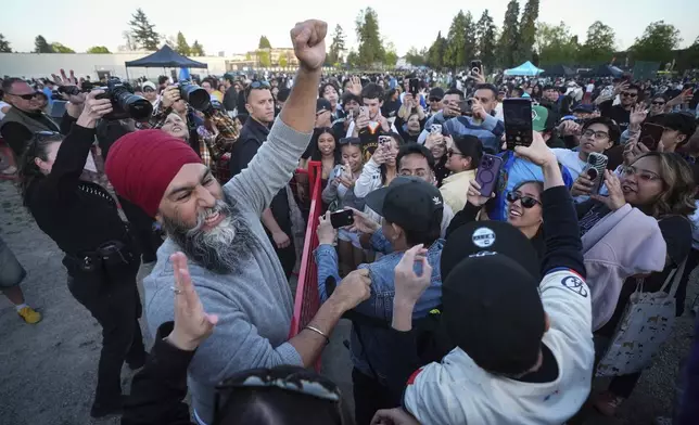 NDP Leader Jagmeet Singh greets attendees during a campaign stop at a Lapu Lapu Day block party, in Vancouver, British Columbia, Saturday, April 26, 2025. (Darryl Dyck/The Canadian Press via AP)