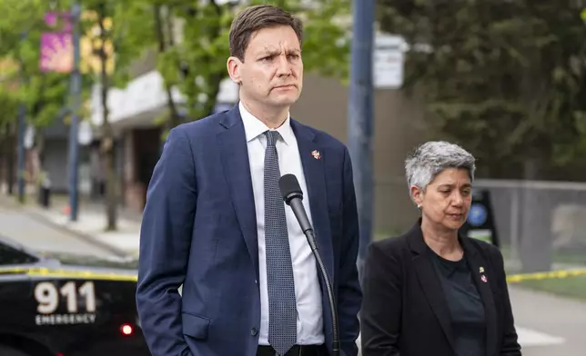 British Columbia Premier David Eby, left, and Member of the Legislative Assembly of B.C., Mable Elmore, deliver remarks after a vehicle drove into crowd during a Lapu Lapu Day festival in Vancouver, British Columbia, Sunday, April 27, 2025. (Rich Lam/The Canadian Press via AP)
