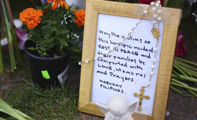 A handwritten note in a frame is seen at a growing memorial for victims the day after a driver killed multiple people during a Filipino community festival Sunday, April 27, 2025, in Vancouver, British Columbia. (AP Photo/Lindsey Wasson)