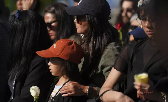 People visit a memorial after a vehicle drove into a crowd during a Filipino heritage festival in Vancouver, British Columbia, Sunday, April 27, 2025. (AP Photo/Lindsey Wasson)