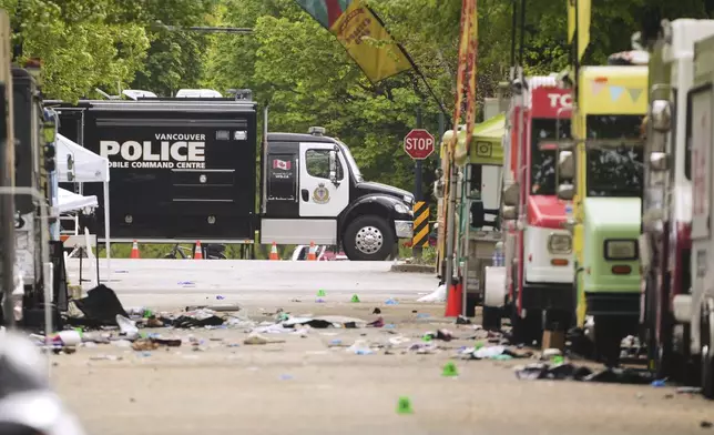 Evidence markers and Vancouver Police vehicles sit at a scene after a driver killed multiple people Saturday during a Filipino community festival Sunday, April 27, 2025, in Vancouver, British Columbia. (AP Photo/Lindsey Wasson)