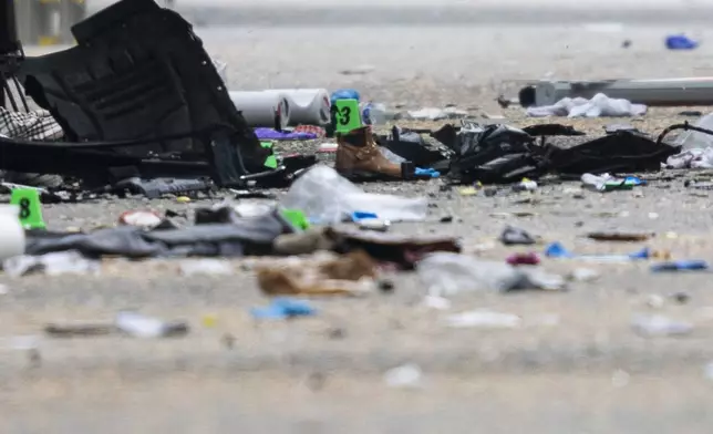 Debris and evidence markers lay on the street while police investigate after a vehicle drove into a crowd at a street festival Saturday evening killing multiple people, in Vancouver, British Columbia, Sunday, April 27, 2025. (Rich Lam/The Canadian Press via AP)