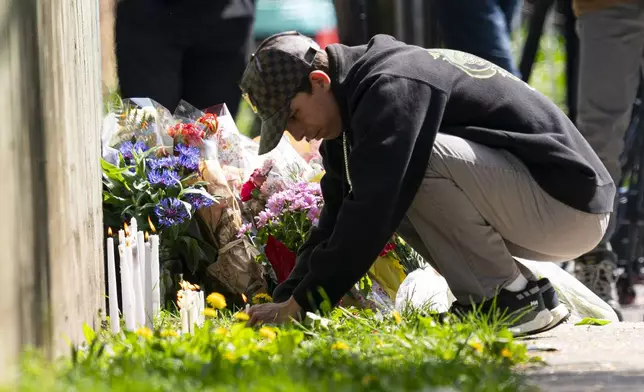 A member of the public lights a candle near the scene where a vehicle drove into crowd on Saturday at a street festival killing multiple people, in Vancouver, British Columbia, Sunday, April 27, 2025. (Rich Lam/The Canadian Press via AP)