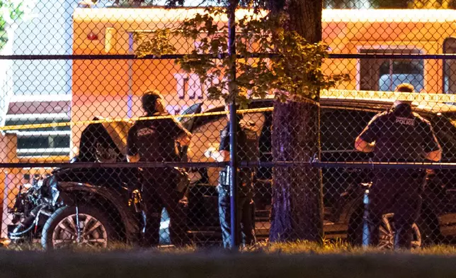 Vancouver police examine a black car suspected to be involved at a scene after a vehicle drove into a crowd at the Lapu Lapu Festival in Vancouver, British Columbia, Saturday April 26, 2025. (Rich Lam/The Canadian Press via AP)