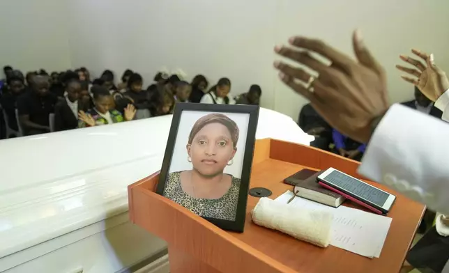 Mourners listen during the funeral service of Nigerian Ladi Anzaki Olubunmi, a TikTok content moderator employed by subcontractor Teleperformance, at Chiromo Funeral Parlour in Nairobi, Kenya Thursday, April. 17, 2025. (AP Photo/Brian Inganga)