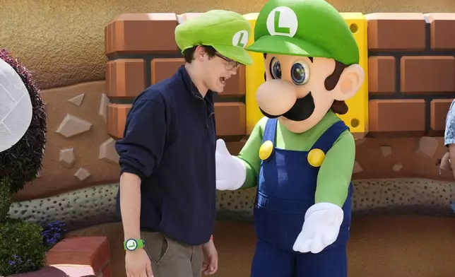 A guest interacts with a character in Super Nintendo World at Epic Universe at Universal Resort Orlando Thursday, April 10, 2025, in Orlando, Fla. (AP Photo/John Raoux)
