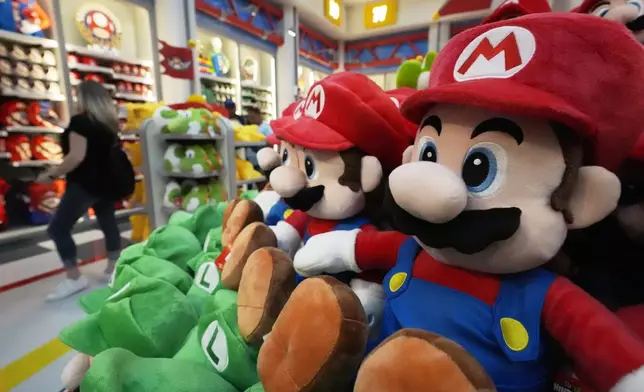 A shopper looks over merchandise for sale in a gift shop at Super Nintendo World at Epic Universe Theme Park at Universal Resort Orlando Thursday, April 10, 2025, in Orlando, Fla. (AP Photo/John Raoux)
