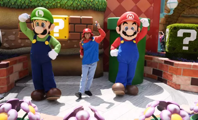 A guest interacts with characters in Super Nintendo World at Epic Universe at Universal Resort Orlando Thursday, April 10, 2025, in Orlando, Fla. (AP Photo/John Raoux)
