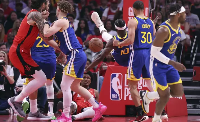 Golden State Warriors' Jimmy Butler III falls towards the court after being fouled by Houston Rockets' Amen Thompson in 1st quarter of Game 2 of First Round of NBA Playoffs in Houston, Texas on Wednesday, April 23, 2025. (Scott Strazzante/San Francisco Chronicle via AP)