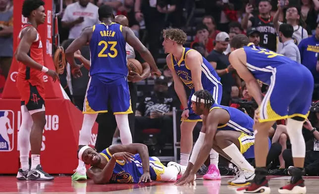 Golden State Warriors' Jimmy Butler III writhes in pain after injuring himself in 1st quarter against Houston Rockets in Game 2 of First Round of NBA Playoffs at Toyota Center in Houston, Texas on Wednesday, April 23, 2025. (Scott Strazzante/San Francisco Chronicle via AP)