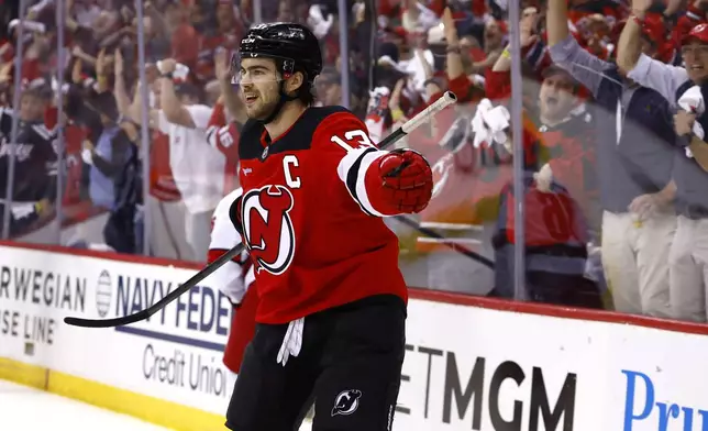 New Jersey Devils center Nico Hischier (13) reacts after scoring against the Carolina Hurricanes during the first period of Game 3 of a first-round NHL hockey playoff series Friday, April 25, 2025, in Newark, N.J. (AP Photo/Noah K. Murray)