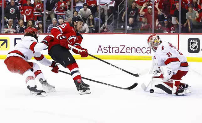 New Jersey Devils left wing Erik Haula,, second from left, has his shot stopped by Carolina Hurricanes goaltender Frederik Andersen (31) during the first period of Game 3 of a first-round NHL hockey playoff series Friday, April 25, 2025, in Newark, N.J. (AP Photo/Noah K. Murray)