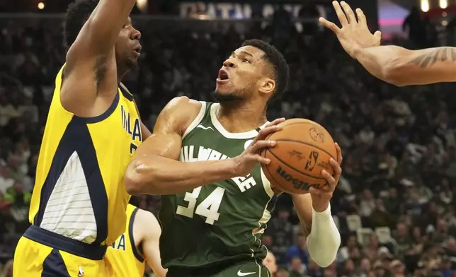 Milwaukee Bucks forward Giannis Antetokounmpo, right, drives against Indiana Pacers center Thomas Bryant, left, during the first half in Game 3 of an NBA basketball first-round playoff series Friday, April 25, 2025, in Milwaukee. (AP Photo/Nam Y. Huh)
