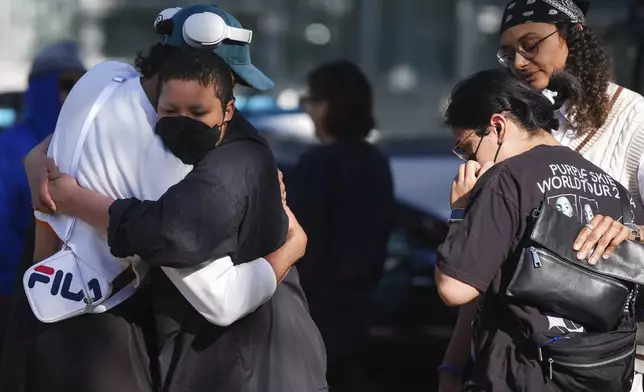 People embrace outside a community meeting for the victims after a vehicle drove into a crowd Saturday and killed multiple people at a Filipino heritage festival, in Vancouver, British Columbia, Sunday, April 27, 2025. (Darryl Dyck/The Canadian Press via AP)
