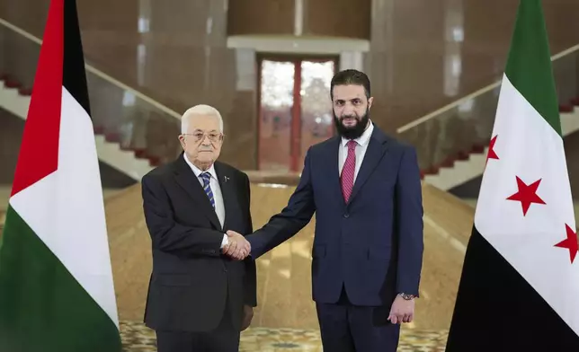 In this photo released by the Syrian Presidency press office, Syrian President Ahmad al-Sharaa, right, shakes hands with Palestinian Authority President Mahmoud Abbas in Damascus, Syria, Friday, April 18, 2025. (Syrian Presidency press office via AP)