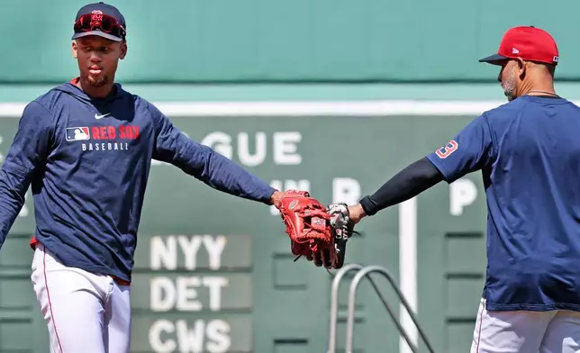 Boston Red Sox's Kristian Campbell, left, bumps gloves with manager Alex Cora before a baseball game against the Toronto Blue Jays, Thursday, April 10, 2025, in Boston. (AP Photo/Jim Davis)