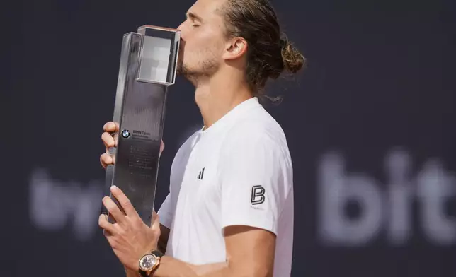 Germany's Alexander Zverev kisses the trophy after winning the tennis final match against Ben Shelton of the US at the ATP Tour in Munich, Germany, Sunday, April 20, 2025. (AP Photo/Matthias Schrader)