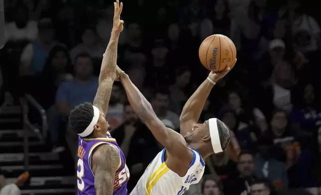 Golden State Warriors forward Jimmy Butler III (10) shoots over Phoenix Suns guard Bradley Beal (3) during the first half of an NBA basketball game in Phoenix, Tuesday, April 8, 2025. (AP Photo/Darryl Webb)
