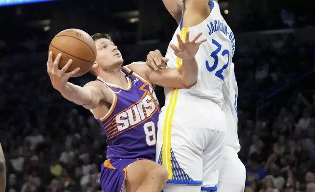 Phoenix Suns guard Grayson Allen (8) attempts to shoot around Golden State Warriors forward Trayce Jackson-Davis (32) during the first half of an NBA basketball game in Phoenix, Tuesday, April 8, 2025. (AP Photo/Darryl Webb)