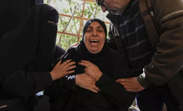A Relative of 10 members of the Abu Al-Rous family, killed when an Israeli airstrike struck their displacement tent overnight, reacts during their funeral in Khan Younis, southern Gaza Strip, Thursday, April 17, 2025. (AP Photo/Abdel Kareem Hana)